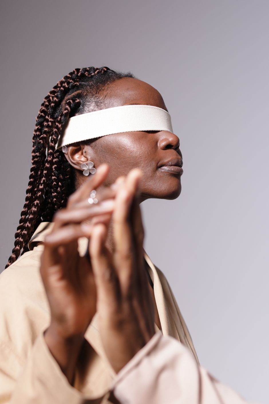 A side view portrait of a blindfolded African woman with braided hair, exploring perception.