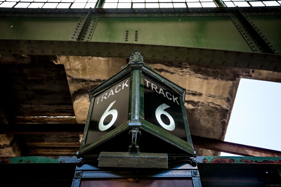 Low angle view of a vintage Track 6 sign at a railway station, showcasing rustic industrial architecture.
