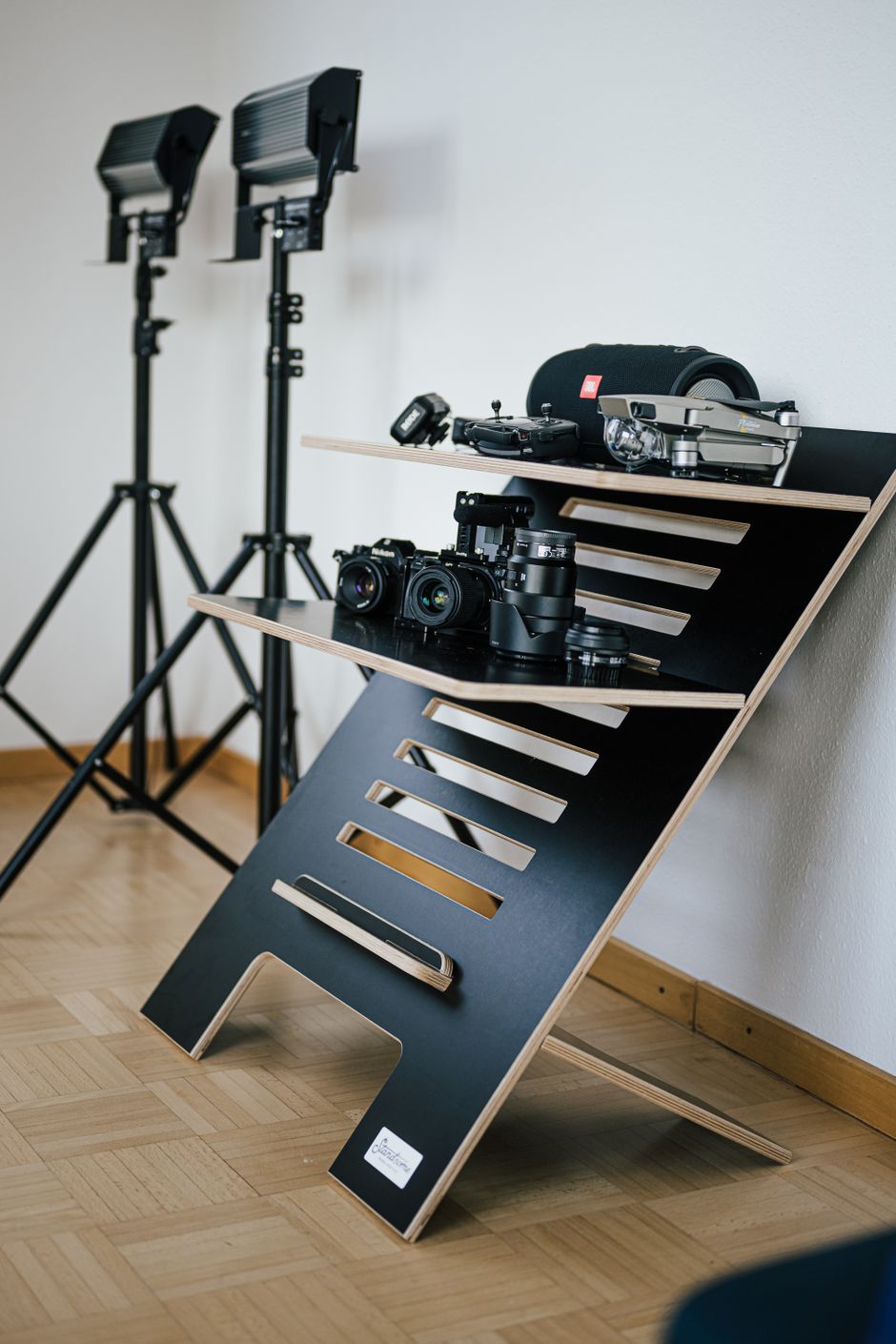 A contemporary photo workspace setup featuring cameras and lighting gear in a studio.