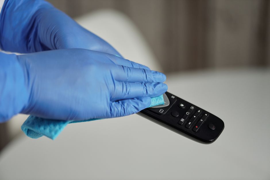 Sanitizing TV remote with alcohol wipe