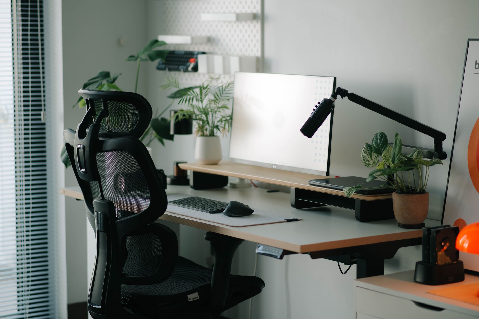 Person alternating between sitting and standing at adjustable desk